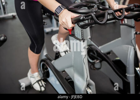 Woman working out on exercise bike at spinning class Stock Photo