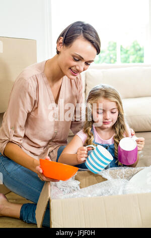Mother and daughter removing containers from box Stock Photo