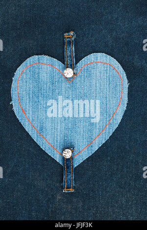 Frame made of jeans in the shape of a heart, lies on a denim fabric. With a place for your text Stock Photo