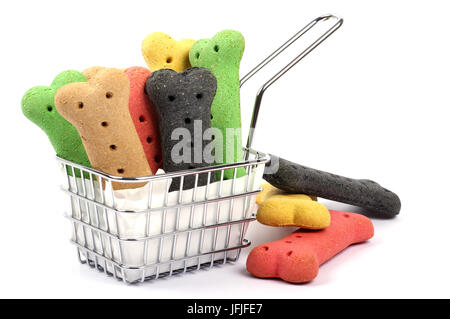 basket of dog biscuits on a white background with three biscuits fallen to the side Stock Photo