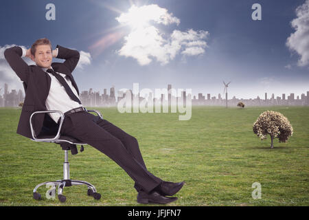 Composite image of businessman relaxing in swivel chair Stock Photo