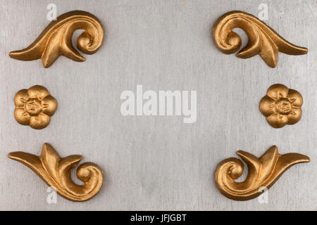 Luxury frame made of golden stucco plaster lying on silver surface, with space for your text Stock Photo