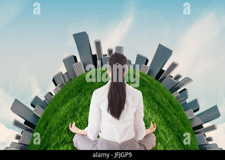 Composite image of businesswoman sitting in lotus pose Stock Photo