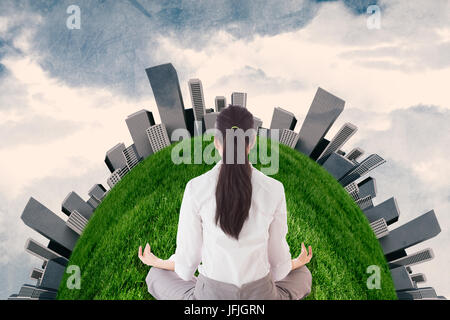Composite image of businesswoman sitting in lotus pose Stock Photo