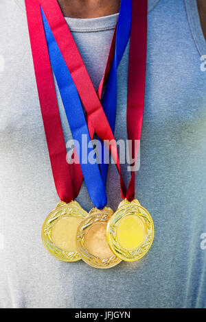 Athlete posing with gold medals around his neck Stock Photo