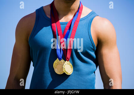 Athlete posing with gold medals around his neck Stock Photo