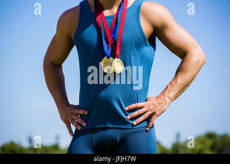 Athlete posing with gold medals around his neck Stock Photo