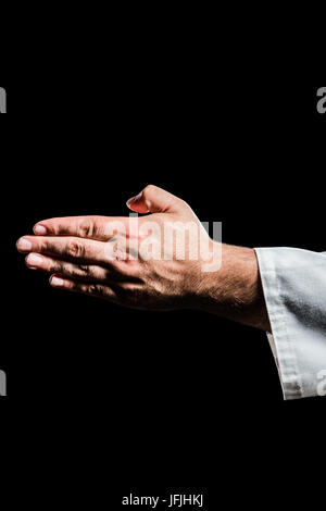Karate player making hand gesture on black background Stock Photo
