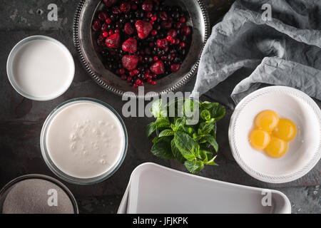 Berries , eggs , cream , sugar  and mint on the stone background top view Stock Photo