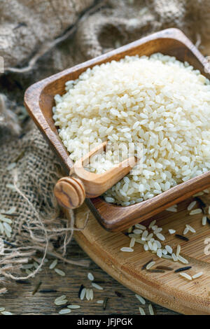 Wooden scoop in bowl with white rice close up. Stock Photo
