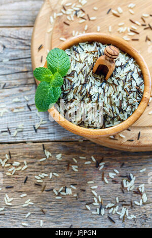 Mixture of white and wild rice in a wooden bowl. Stock Photo