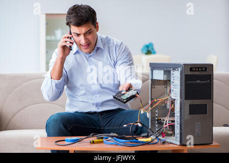 The angry customer trying to repair computer with phone support Stock Photo