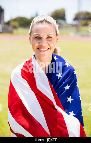 Portrait of female athlete wrapped in american flag Stock Photo