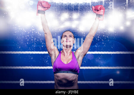 Composite image of winner female boxer with arms raised Stock Photo