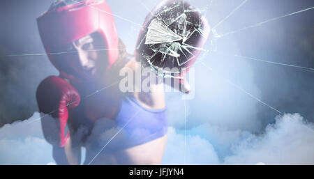 Composite image of female boxer with gloves and headgear punching Stock Photo