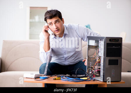Angry customer trying to repair computer with phone support Stock Photo