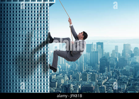 Businessman in challenge concept climbing skyscraper Stock Photo