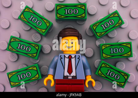 Tambov, Russian Federation - June 22, 2017 Lego businessman and Lego money on gray baseplate background. Studio shot. Stock Photo