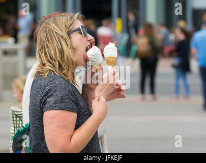 Woman eating 99 flake ice cream on a hot day in Summer in the UK. Stock Photo