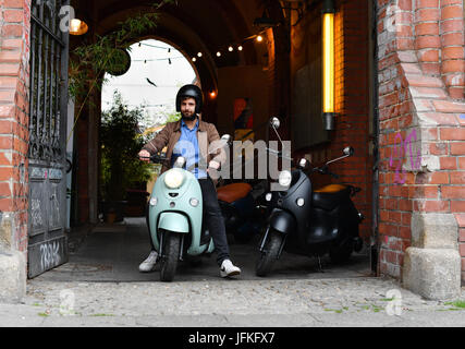 Berlin, Germany. 29th June, 2017. A person drives a scooter from the mobility start up 'Unu' in Berlin, Germany, 29 June 2017. Unu Motors is one of the world's fast rising brand oriented start ups, according a study of brand consulting. They are thus one of the 'Breakthrough Brands'. The Berliners have been producing the electronic scooters since 2014. The start up began expanding into other European countries in 2016 Photo: Jens Kalaene/dpa-Zentralbild/ZB/dpa/Alamy Live News Stock Photo