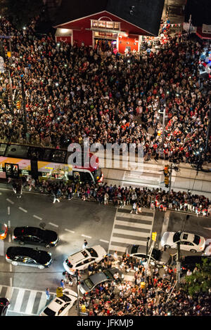 Toronto, Canada. 1st July 2017. A large crowd gathered around Queens Quay and York Street, which offers a direct viewing of CN Tower, awaiting for the Canada's Day firework display in Toronto. Dominic Chan/EXimages Stock Photo