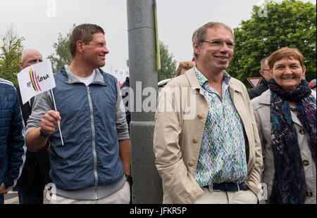 Korschenbroich, Germany. 02nd July, 2017. Former professional cyclist Jan Ullrich (L) stands on the sidewalk holding a flag and awaits with fans for the arrival of the peloton in Korschenbroich, Germany, during the Dusseldorf-Luttich stretch, the 2nd stage of the Tour de France, part of the UCI World Tour, 02 July 2017. Photo: Guido Kirchner/dpa/Alamy Live News Stock Photo