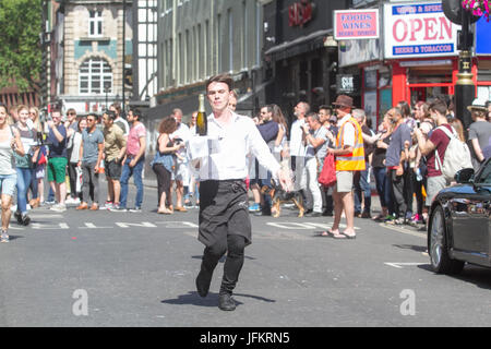 Soho, London. 2nd July, 2017. Waiters run around streets of Soho carrying  a tray in one hand, loaded up with a napkin, half a bottle of champagne and a champagne glass raising funds for new charity The Waiters Benevolent Fund for struggling waiters Credit: amer ghazzal/Alamy Live News Stock Photo