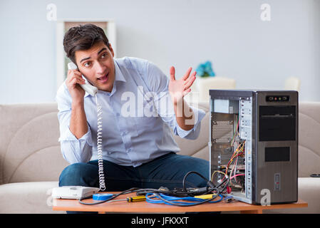 Angry customer trying to repair computer with phone support Stock Photo