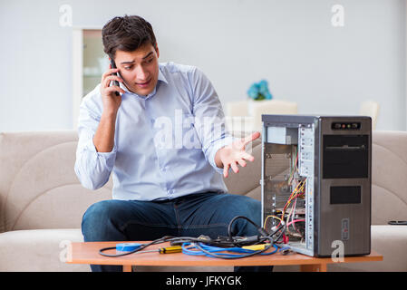 Angry customer trying to repair computer with phone support Stock Photo