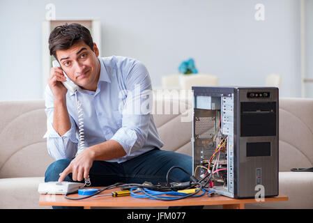 Angry customer trying to repair computer with phone support Stock Photo