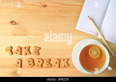 Hot Lemon Tea, Note Papers and Pencil beside with Word TAKE A BREAK Spelling with Cookies on Wooden Table Stock Photo