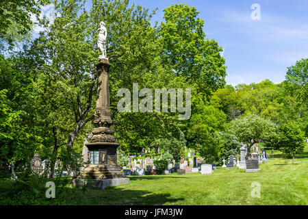 Montreal, Canada - May 28, 2017: Cemetery on Mont Royal with statue during bright sunny day in Quebec region city Stock Photo