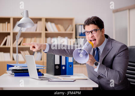 Businessman with loudspeaker megaphone in office Stock Photo