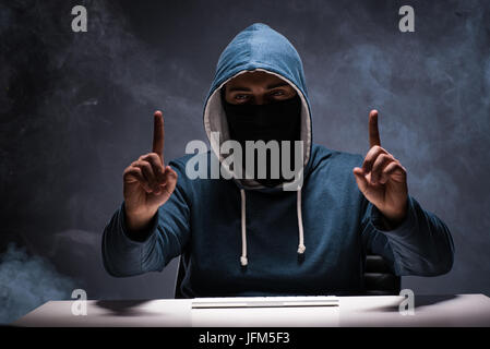 Computer hacker working in dark room Stock Photo