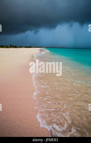 Storm clouds on fine sand framed by the turquoise sea Pink Sand Beach Antigua and Barbuda Leeward Islands West Indies Stock Photo