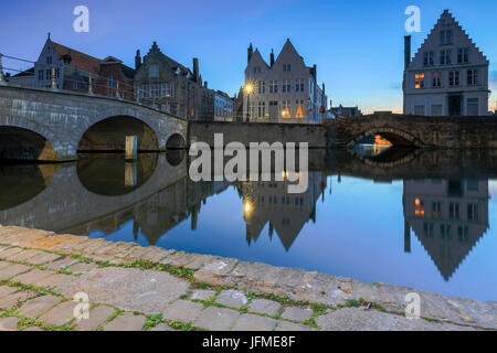 Dusk lights on the historic buildings of the city centre reflected in the typical canals Bruges West Flanders Belgium Europe Stock Photo