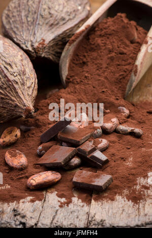 cocoa pods with cocoa beans, cocoa powder and chocolate block on wooden table Stock Photo