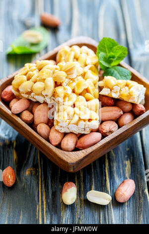 Honey bars with peanuts in bowl with a whole peanut. Stock Photo