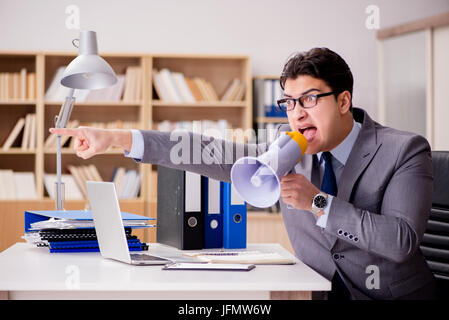 Businessman with loudspeaker megaphone in office Stock Photo
