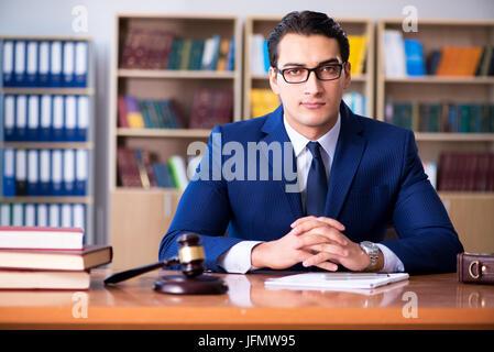 Handsome judge with gavel sitting in courtroom Stock Photo