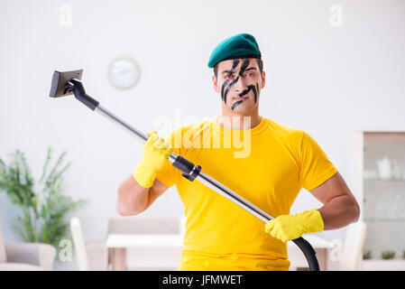 Funny man in military style cleaning the house Stock Photo