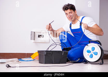 The funny man doing electrical repairs at home Stock Photo