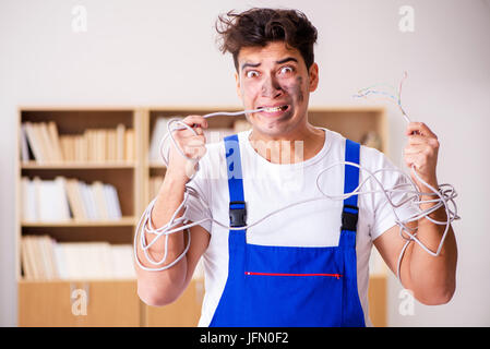 The funny man doing electrical repairs at home Stock Photo