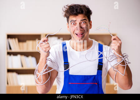 The funny man doing electrical repairs at home Stock Photo