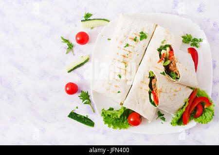 Burritos wraps with minced beef and vegetables on a light background. Flat lay. Top view Stock Photo