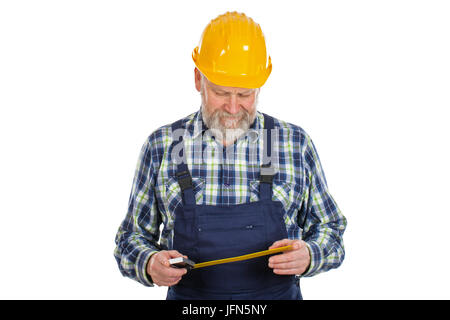 Picture of an elderly builder with construction instruments in his hands posing on isolated background Stock Photo