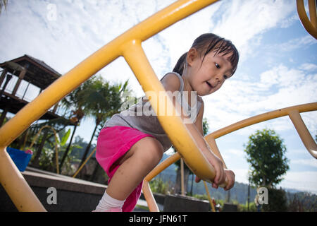 Asian Chinese little girl climbing stepladder at outdoor playground Stock Photo