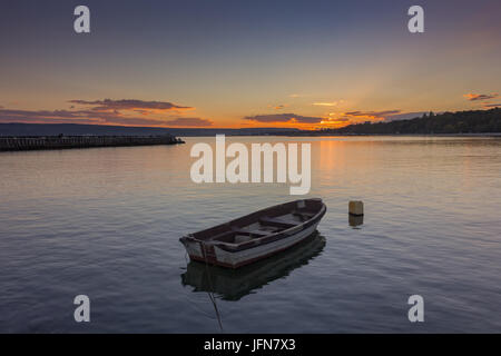 boat in calm water at sunset Stock Photo
