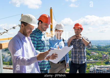 Group Of Builders In Hardhats Meeting On Construction Site Building Team Working With Plan Engineer Teamwork Stock Photo
