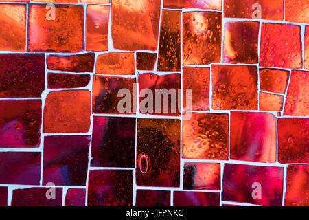 Red glass mosaic tiles with air bubbles inside. Stock Photo